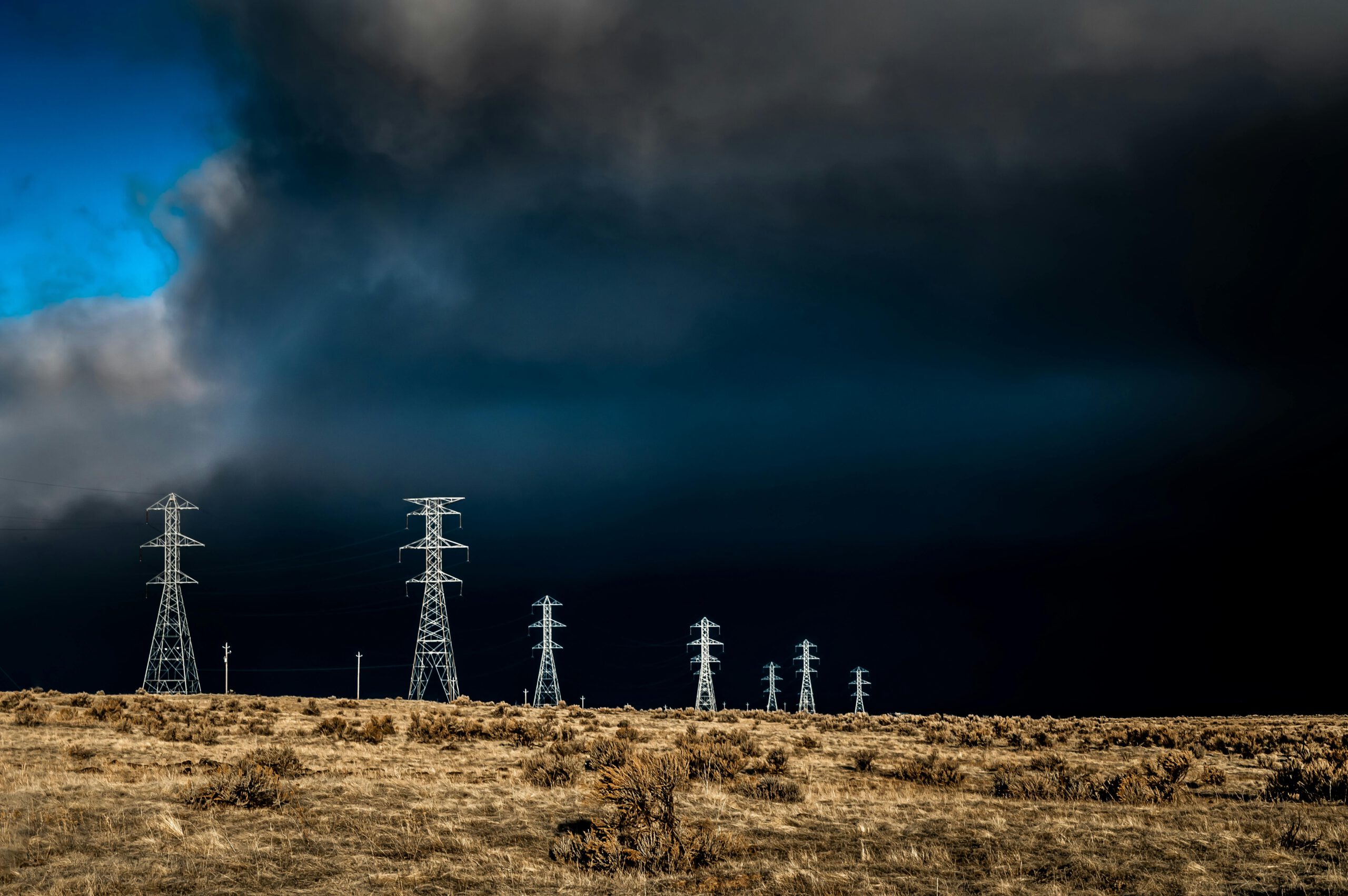 Cyberangriffe an Feiertagen. Strommasten vor dunklen Wolken